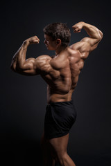 Handsome power bodybuilder showing his back