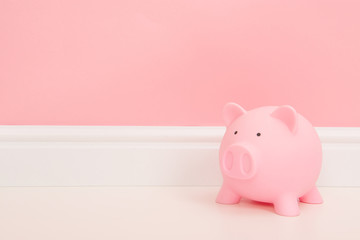 Pink piggy bank on a living room setting with a bank background