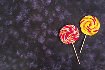Colorful lollipops on dark background. Top view