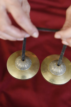 Tibetan prayer cymbals ting-shas and woman in monk's dress