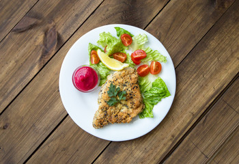 Homemade Breaded Schnitzel with salad and berry sauce