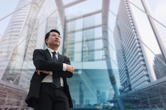 Confident Asian Businessman standing and looking at city for vision concept