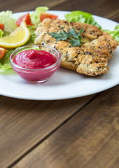 Homemade Breaded Schnitzel with salad and berry sauce