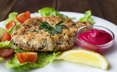 closeup of Homemade Breaded Schnitzel with salad and berry sauce