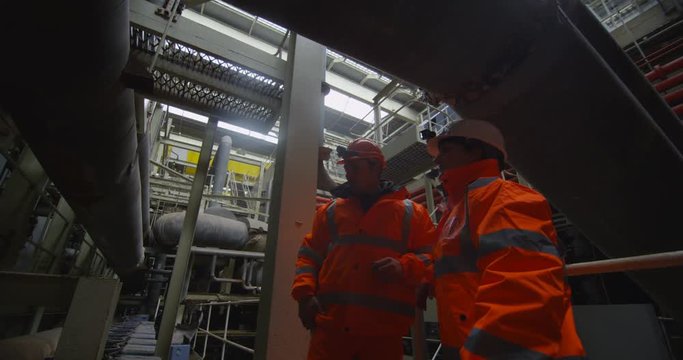  Male & female engineers conducting checks inside power plant