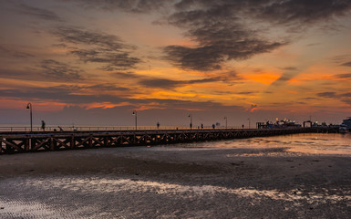 Obraz premium Long pier at sunset, orange-red sky