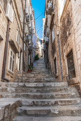Fototapeta na wymiar Narrow stone steps going up from the old town in Dubrovnik to streets and alleys above.