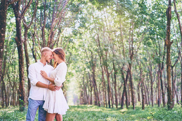 Naklejka na ściany i meble Love and tenderness. Beautiful young loving couple embracing in green garden. Romantic dating.