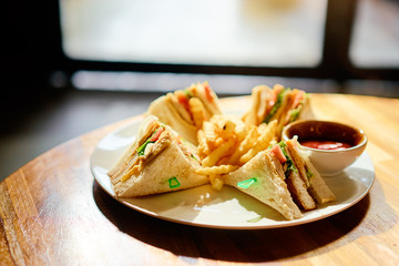 Tasty fast food. Traditional club sandwich with french fries.