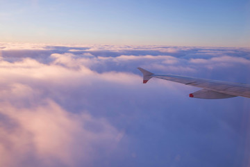 Aircraft wing over clouds, flying background clouds over USA