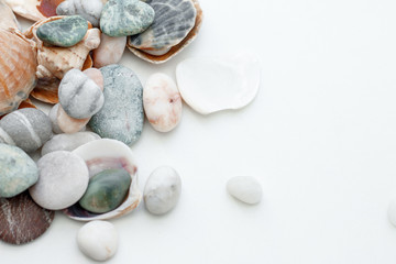 Fototapeta na wymiar Stones and seashells in a vase on a white background. Reminder of the sea
