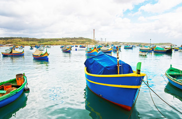 Fototapeta na wymiar Luzzu colored boats at Marsaxlokk Bay in Malta