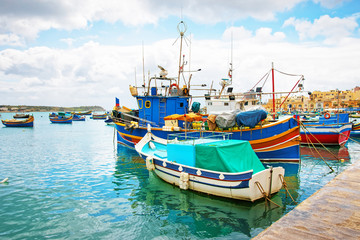 Fototapeta na wymiar Luzzu colored boats at Marsaxlokk Harbor at Malta
