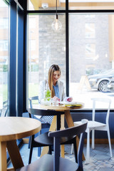 Beautiful Young Woman Sitting in Coffee Shop