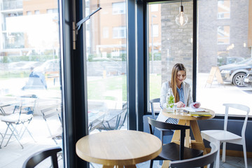 Beautiful Young Woman Sitting in Coffee Shop