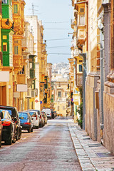 Fototapeta na wymiar Old street with traditional houses in city center Valletta