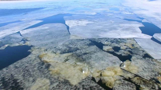 4K. Floating cracked ice and sludge on river. Aerial.
