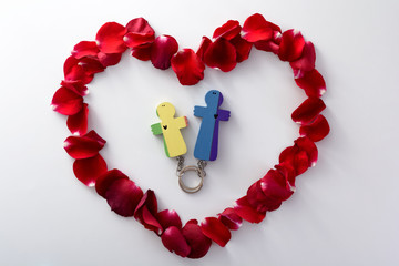 Obraz premium Wooden figures of father and daughter into heart from rose petals