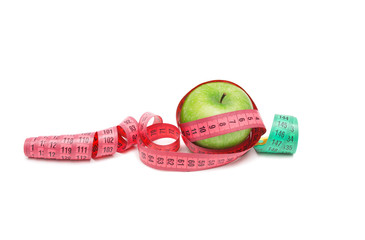 Green apple with colored measuring tapes isolated on white