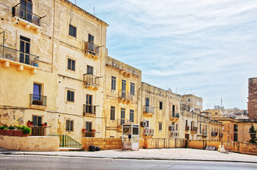 Fototapeta na wymiar Street with traditional houses at old city center Valletta