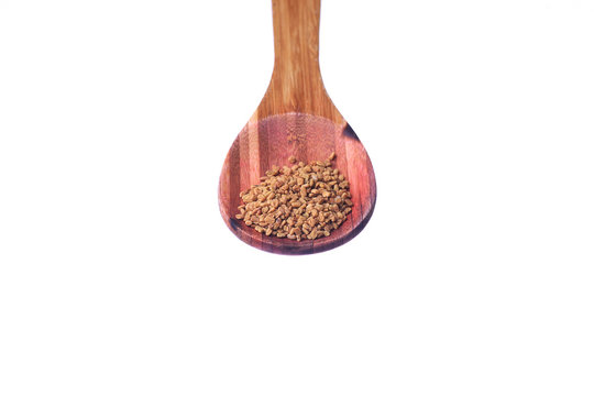 Fenugreek seeds on a brass spoon isolated on a white background. - Powered by Adobe