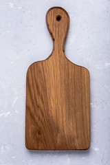 Oak cutting board on light gray plaster texture background