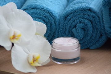 Obraz na płótnie Canvas Cream with folded towels and orchid