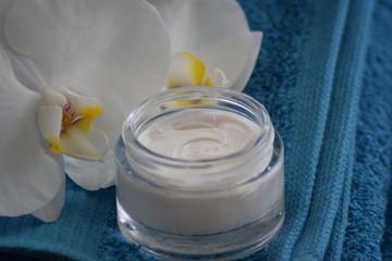 Fototapeta na wymiar Cream with folded towel and orchid 