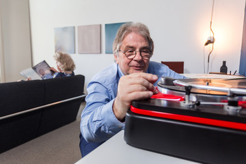a man carefully placing the needle on a vinyl record