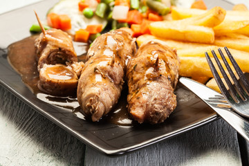 Pork rolls with french fries with vegetable