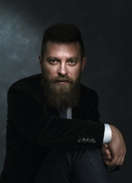 Portrait of handsome young bearded businessman in classic suit.