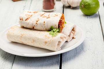Mexican burritos wraps with mincemeat, beans and vegetables