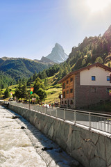 Fototapeta premium Traditional Swiss chalets and Gornera River and Matterhorn summit