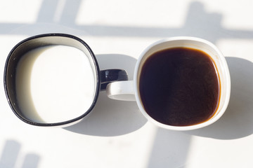 black and white cup of milk, coffee on natural background, top view