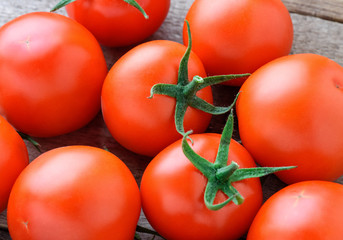Fresh juicy tomatoes on an old wooden table. Tomatoes on a wooden background.