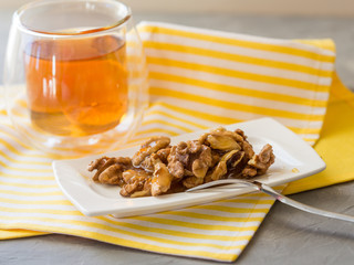 Honey in white jar, nuts, top view cup of tea in glass