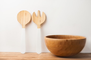 Wooden bowl and cutlery on white background and table. Natural serving table setting