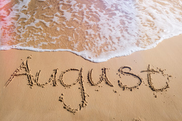 August written on beach, end of summer concept