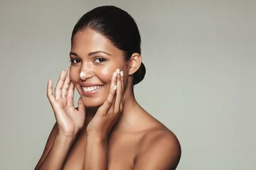 Poster Smiling female model applying moisturizer © Jacob Lund