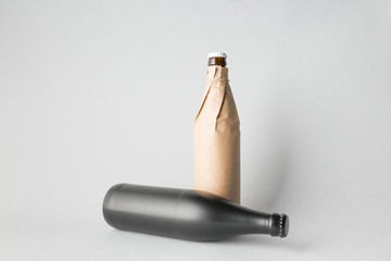 The composition of two bottles: one stands and the other is tipped over