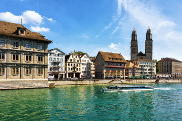 River cruiser at Limmat River and Grossmunster Church in Zurich