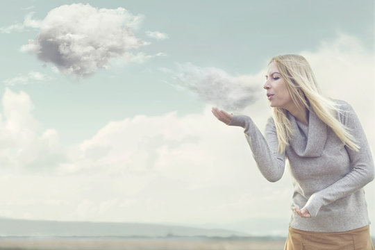 woman with magical powers creating clouds blowing