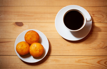 Cakes and cup of coffee on wooden table