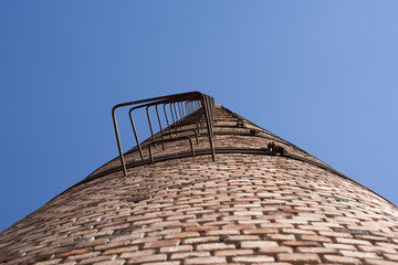 Obraz premium old factory's chimney looks like stairway to infinity