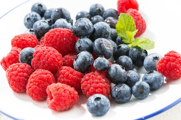 plate with fresh berries on a white background, closeup
