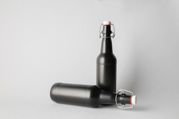 The composition of two bottles: one stands and the other is tipped over