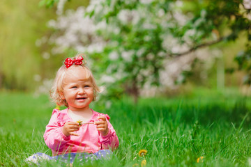 cute little girl with flowers in spring nature