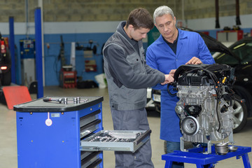 student with instructor repairing a car during apprenticeship