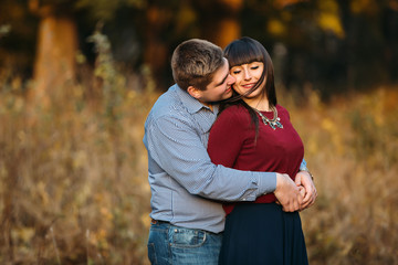 Lovers kiss on sunset in  forest