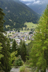 Fototapeta na wymiar Beautiful village in the Dolomites mountains seen from the beautiful road ( Strada Veia de Muncion) to Gardeccia refuge, Northern Italy, South Tyrol, Italy, Europe